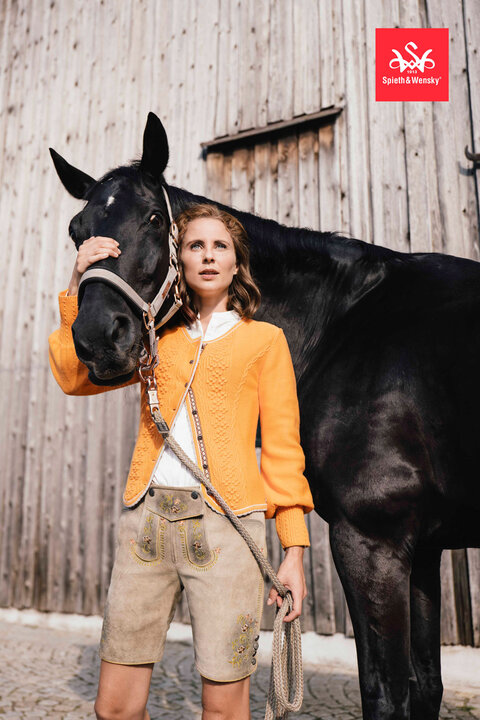 weiche Lederhose kombiniert mit einer Trachtenbluse und einer gelben Strickjacke